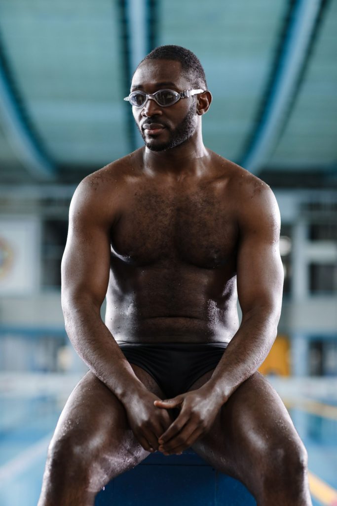 Atleta seduto a bordo piscina prima di una sessione di allenamento